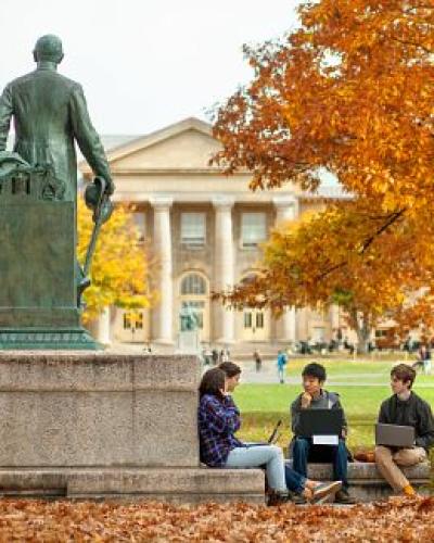 Students study near the statue of Ezra Cornell on the Arts Quad in fall. Students gathered next to the Ezra Cornell statue.