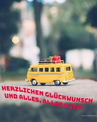 Bus with luggage on top. German text: Herzlichen Gluckwunscch und alles, alles gute!